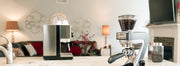 A Baratza coffee grinder in a white kitchen, next to a Gaggia Classic Pro espresso machine