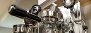 Closeup of a portafilter locked into the E61 brew group of an espresso machine