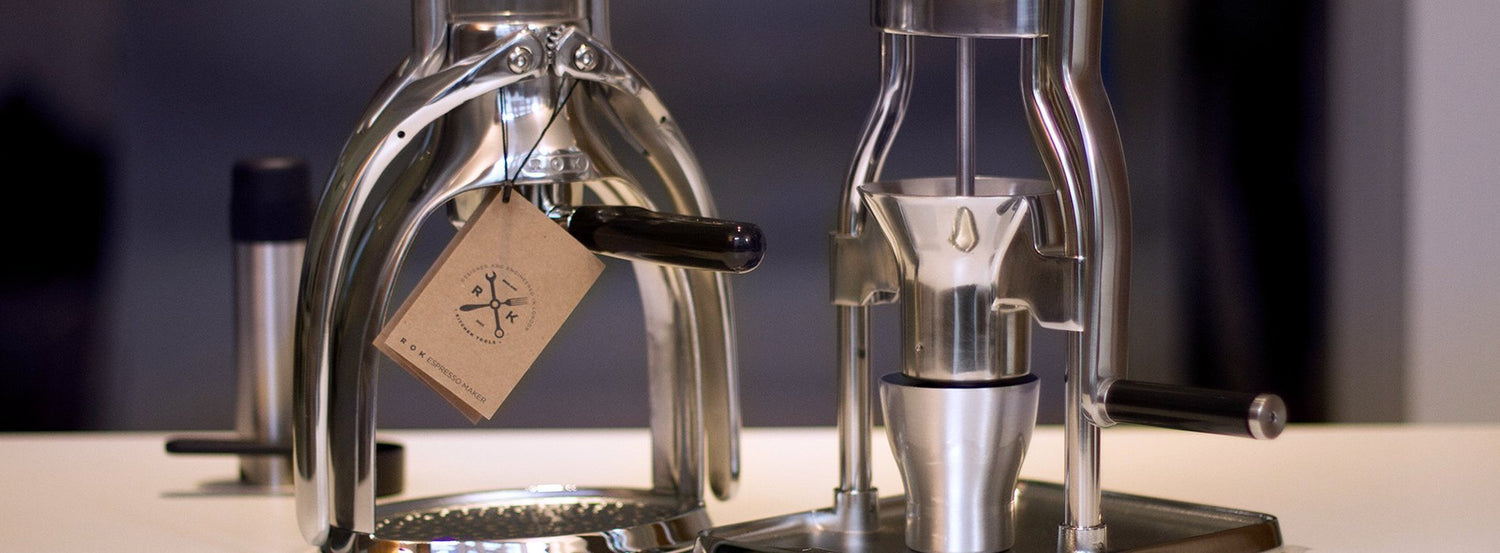 A manual coffee grinder next to a manual espresso maker.
