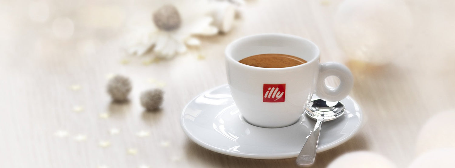 An illy coffee branded cup and saucer, filled with espresso