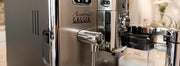 A closeup shot of the frothing and steaming parts of an espresso machine.