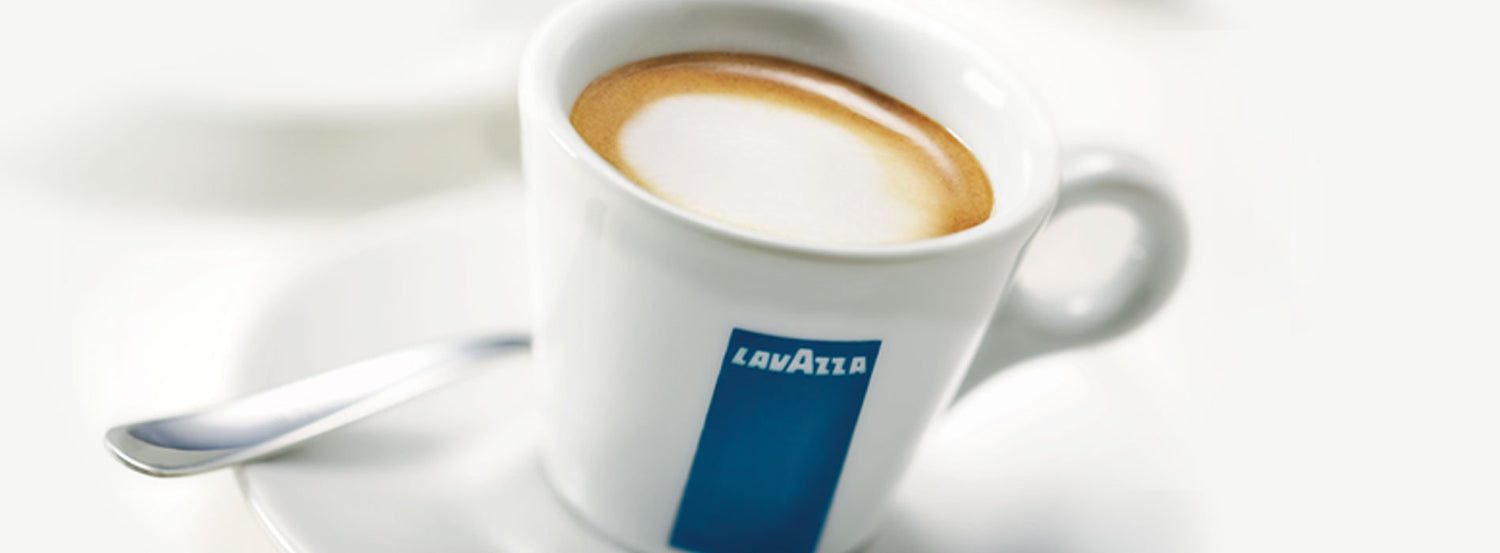 Espresso in a white espresso cup with a blue stripe and Lavazza logo