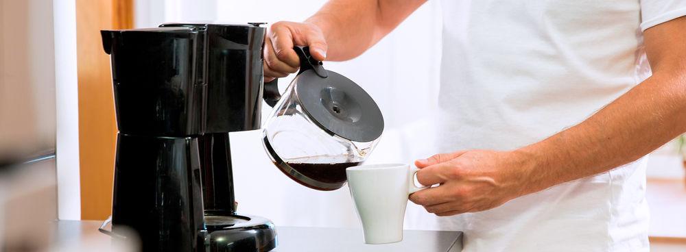 A person dressed in white making some coffee with a Bonavita coffee maker