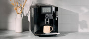 Close-up of the JURA S8 machine with a cup on a white countertop in a kitchen setting.