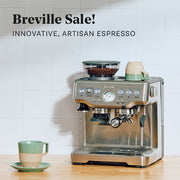 Breville Barista Touch on a wooden counter next to a green and brown coffee cup with promotional text that reads, "Breville Sale! Innovative, Artisan Espresso!".