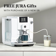 JURA E6 with a Glass Milk Container on a counter top with promotional text that reads "Free Gifts with JURA E6 Purchase".