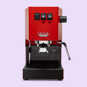 Cherry Red Gaggia Classic E24 machine on a light purple background.