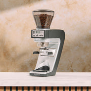 Coffee grinder with coffee beans on a marble countertop