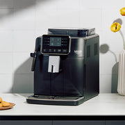 Black Gaggia Cadorna Plus on a wite counter in front of a white tiled wall.